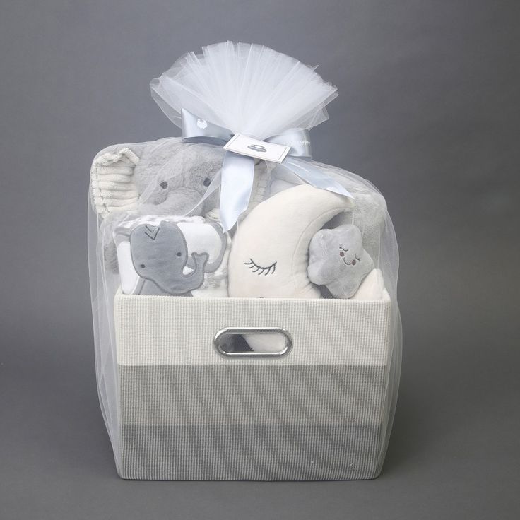 a baby gift basket with stuffed animals in it on a gray background and white tulle