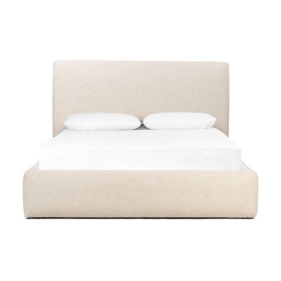 a bed with two pillows on top of it and white sheets in the bottom half