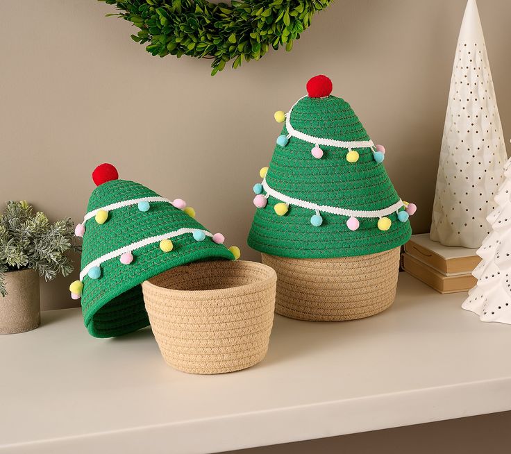 two knitted christmas trees sitting on top of a table