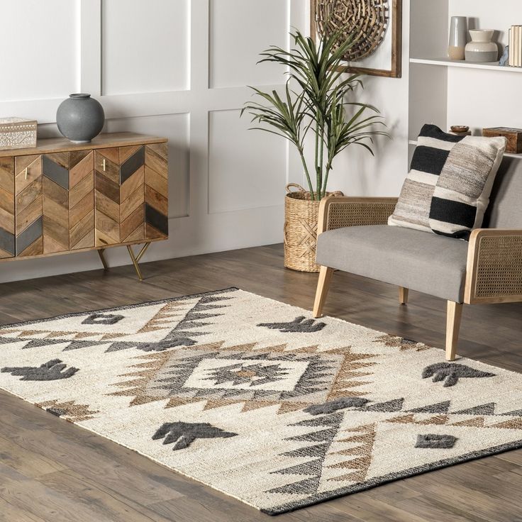 a living room filled with furniture and a rug on top of a hard wood floor