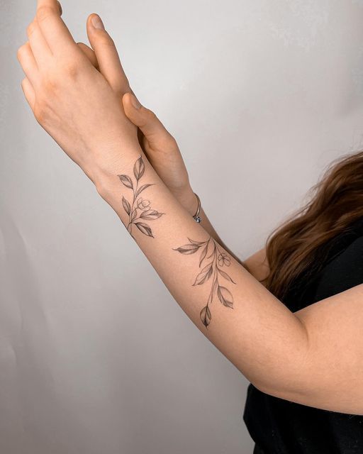 a woman with a tattoo on her arm is holding out her hand to the camera