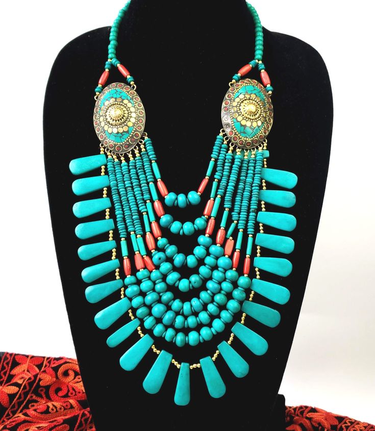 This is a lot of necklace Simulated coral and turquoise bead multi strand statement necklace. Stand out in this striking necklace! 8 full strands of resin beads cascading down from two brass medallions which anchor the strands. First strand starts at 9 inches and last strand is at 14 inches. In a beautiful turquoise/teal blue color of imitation turquoise with gold colored spacer beads. Or bright red coral, or rainbow color. Hook closure. Brass medallions are detailed, with turquoise and coral re Turquoise Multistrand Necklace, Bohemian Turquoise Bib Necklace With Colorful Beads, Bohemian Bib Necklaces With Large Round Beads, Bohemian Multi-strand Beaded Bib Necklaces, Bohemian Beaded Multi-strand Bib Necklaces, Handmade Bohemian Multi-strand Turquoise Necklace, Handmade Turquoise Bohemian Bib Necklace, Bohemian Turquoise Necklace With Large Beads For Beach, Bohemian Large Beaded Turquoise Necklace For Beach