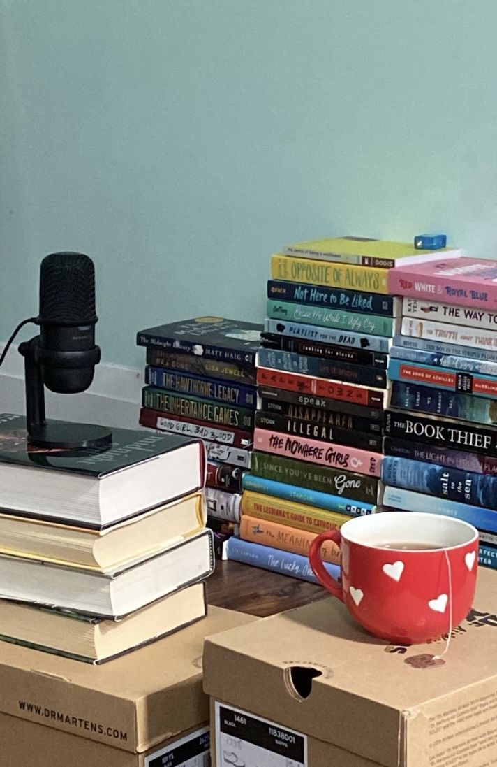 a stack of books with a coffee cup on top