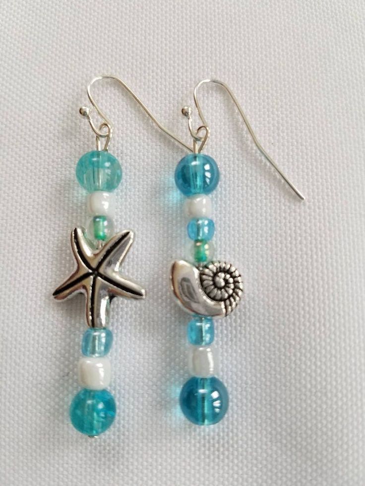 Mismatched Starfish and Shell Earrings.  Shiny and Blue looks so beachy.   These earrings would look great with a matching beaded beachy bracelet.  The piece of jewelry for those who love the beach!  FREE domestic shipping! Beachy Jewelry For Beach Party, Starfish-shaped Beaded Beach Jewelry, Ocean-inspired Jewelry For Beach Party, Starfish-shaped Beaded Jewelry For The Beach, Blue Summer Jewelry With Starfish Charm, Blue Starfish Charm Jewelry For Summer, Beaded Starfish Jewelry For Vacation, Summer Blue Starfish Charm Jewelry, Ocean-inspired Jewelry With Round Beads For Beach Season