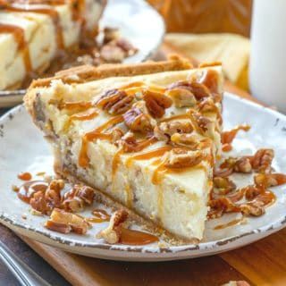 a slice of pecan cheesecake on a plate next to a cup of coffee