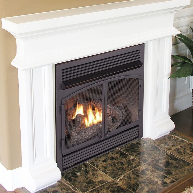 a fireplace with a fire burning in it's mantle next to a potted plant