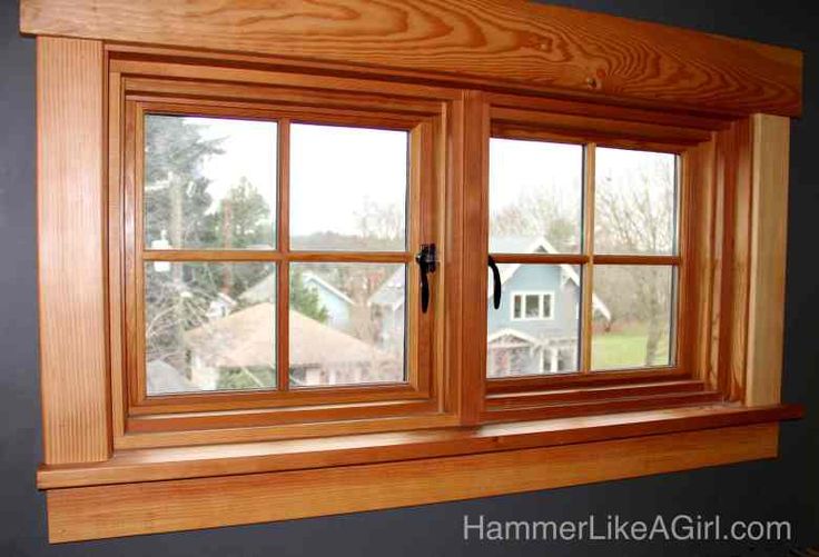 a wooden window in a house with black walls and wood trimming on the windowsill