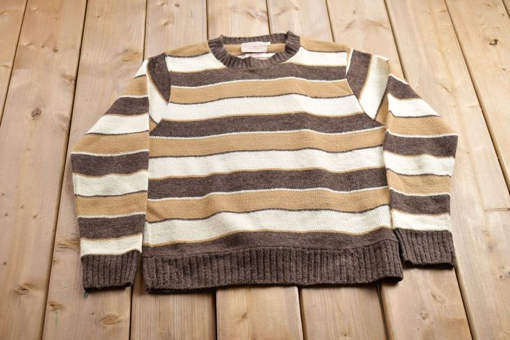 a striped sweater laying on top of a wooden floor