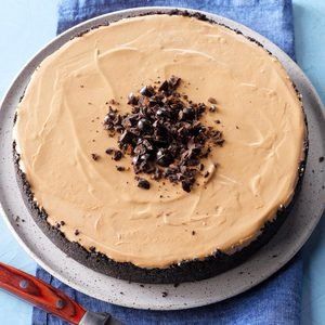 a cake with chocolate chips on top and frosting in the middle sitting on a plate