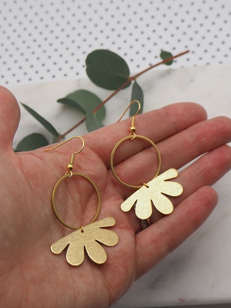 Brass hoop earrings with gold plated hooks. 3.4cm x 1.8cm brushed brass flower shapes sitting on 2.5cm brass hoops with gold plated hooks. Postage: All jewellery items are posted by 1st class recorded delivery with Royal mail, so that you are able to track your order. UK : FREE INTERNATIONAL : £8.00 Gold Metal Flower Charm Earrings, Gold Metal Earrings With Flower Charm, Gold Brass Jewelry In Flower Shape, Gold Metal Earrings With Flower Shape, Gold Metal Flower Shaped Earrings, Gold Metal Earrings In Flower Shape, Gold Hoop Flower Earrings, Single, Brass Dangle Flower Earrings, Single Metal Flower Earring