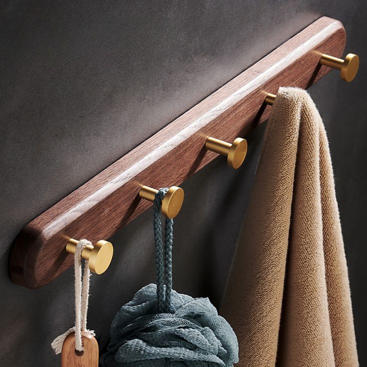 a coat rack with two coats hanging from it's sides and three hooks on the wall