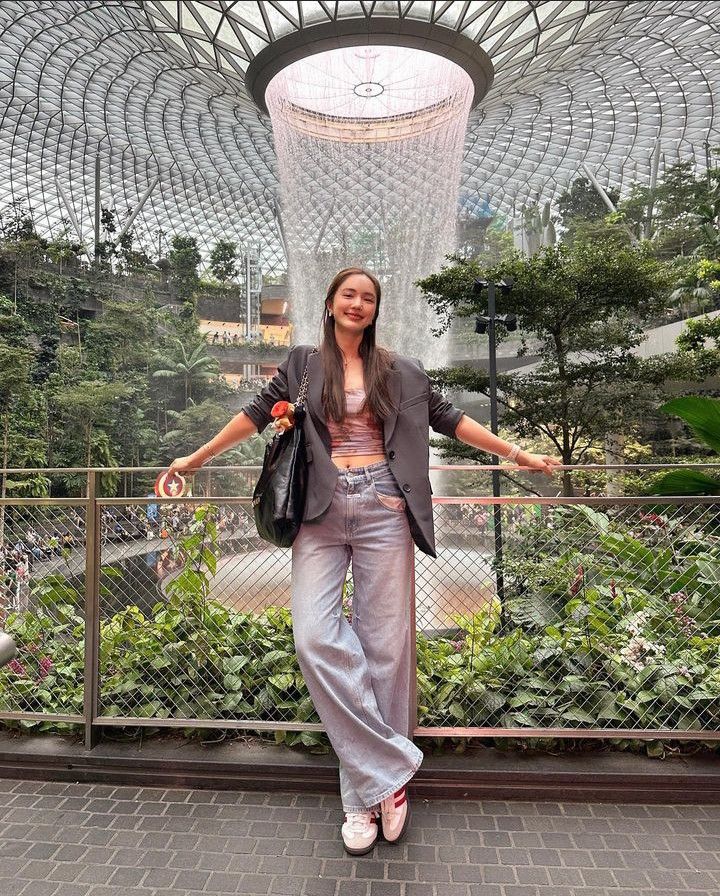 a woman standing in front of a fountain