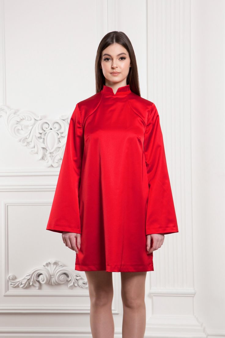 "A modern qipao dress featuring a loose silhouette, mini length and a high neck collar. - modern cheongsam style - mandarin neck - loose silhouette - above the knee length (mini) - loose long sleeves - back metal zipper closure - lined bodice Color: red Fiber: viscose - 40%, elastane - 5%, polyester - 55% Lining: viscose - 95 %, elastane - 5% For Size S: dress length - 33,5\"(85 cm), sleeve length - 23,6\" (60 cm) Our model wears size S (US 6) and is 171cm/5'7\" tall. MORE DRESSES: https://www.e High Neck Long Sleeve Dress For Spring Party, Spring Party High Neck Long Sleeve Dress, Elegant Spring Dress With Band Neckline, Red Stand Collar Dress For Spring, Elegant Knee-length Ao Dai For Party, Elegant High Neck Long Sleeve Dress For Spring, Formal Spring High Neck Mini Dress, Spring Formal High Neck Mini Dress, Spring High Neck Mini Dress For Formal Occasions