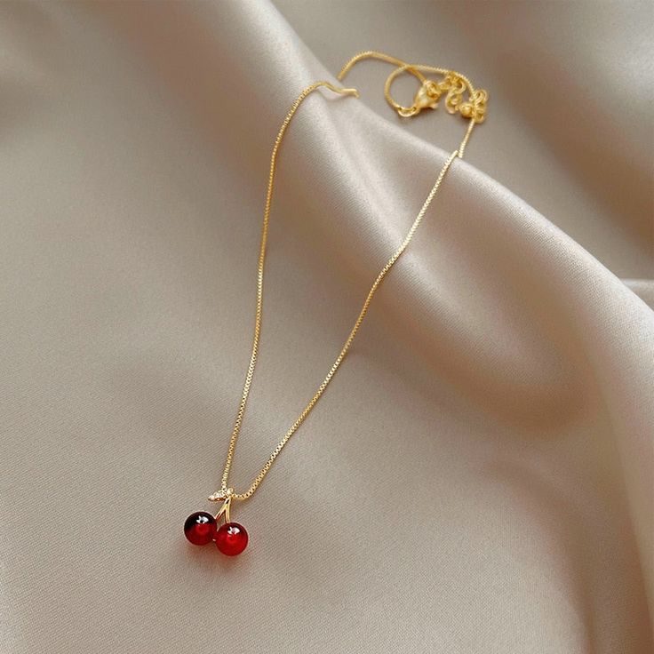 Enhance any outfit with this beautiful Wine Red Cherry Gold Pendant Necklace. Featuring a classic design and bold red hues, it will make a stunning fashion statement that will be admired by all. This statement piece is perfect for your collection. Chic Jewelry For Valentine's Day Gift, Red Round Jewelry, Chic Necklaces For Valentine's Day Party, Chic Valentine's Day Party Necklaces, Chic Valentine's Day Party Necklace, Elegant Cherry Colored Jewelry For Party, Red Pendant Jewelry As Gift For Her, Red Pendant Jewelry As A Gift For Her, Red Ruby Jewelry Gift For Her