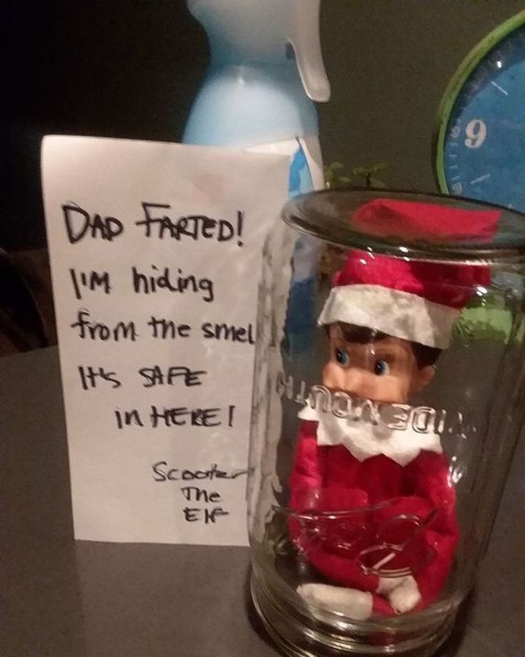 a glass jar filled with an elf figurine next to a sign that says dad faced i'm hiding from the smell it's safe in here