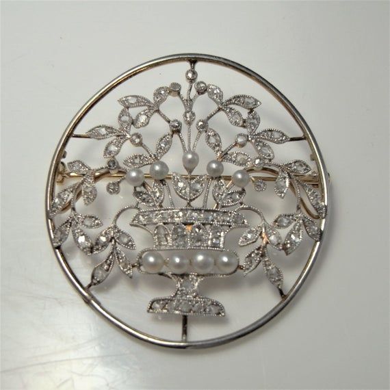 Here we have an antique Art Nouveau pin crafted in platinum and 18K yellow gold and set with rose cut diamonds and natural sea pearls circa 1900. This piece is likely to have hailed from Germany with stylistic motifs consistent with jugendstil which literally translates to youth style being the German equivalent to the Art Nouveau style in France and Europe. The piece is extraordinarily feminine, appearing like lace. The old cut diamonds sparkling beautifully. Across the front of this ethereal j Ornate White Gold Diamond Brooches, Ornate White Gold Diamond Brooch, Antique Wedding Brooch With Intricate Design, Ornate Rose Cut Diamond Brooches For Weddings, Antique White Gold Brooches With Rose Cut Diamonds, Antique Oval Diamond Brooch, Ornate Diamond Brooches For Anniversary, Ornate Diamond Brooch For Anniversary, Victorian Wedding Brooches With Intricate Design