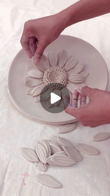 a person is decorating a plate with flowers on it