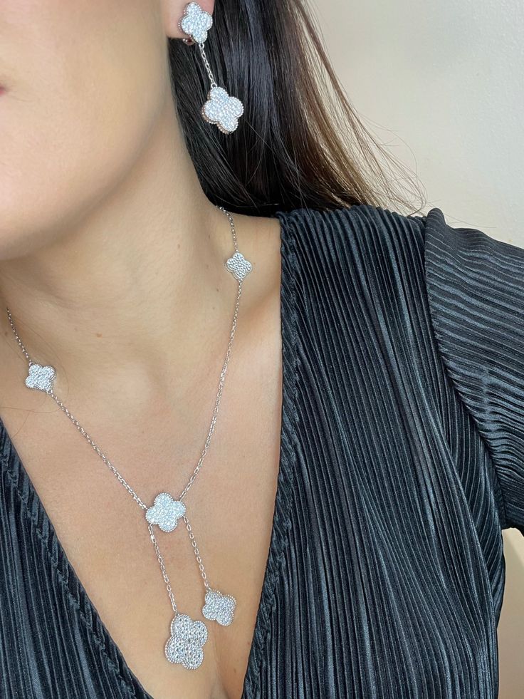 Este exquisito collar está elaborado con circonitas brillantes y tréboles chapados en oro. Una pieza impresionante y elegante que seguramente llamará la atención. Su construcción de alta calidad garantiza un brillo y una belleza duraderos. Flower Shaped Cubic Zirconia Necklaces With Diamond Accents, Flower Shaped Necklace With Diamond Accents And Cubic Zirconia, Cubic Zirconia Flower Shaped Necklace With Diamond Accents, Chic Silver Flower-shaped Jewelry, Flower-shaped Cubic Zirconia Necklace With Diamond Accents, Luxury Silver Flower-shaped Diamond Necklace, Luxury Flower-shaped Clavicle Chain Jewelry, Luxury Silver Diamond Necklace In Flower Shape, Elegant Flower Shaped Clavicle Chain Jewelry