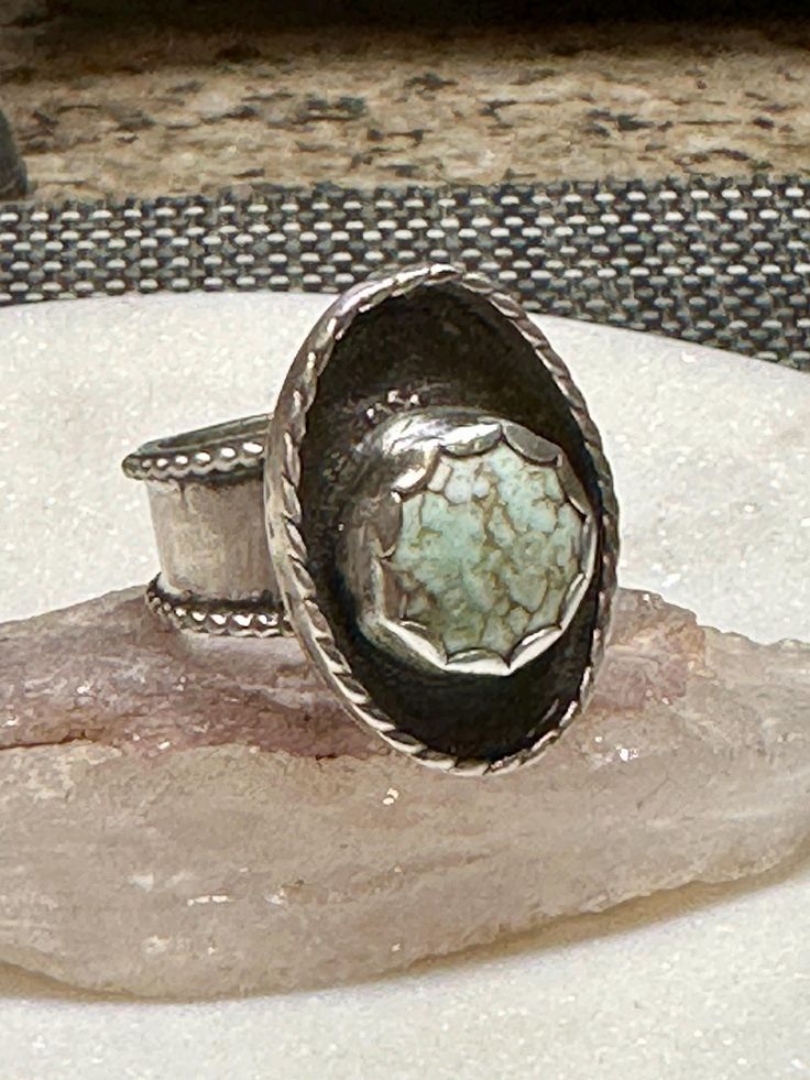 This rare stone is set an asymmetrical sterling silver position and is a size 6 3/4. It can be sized up to 3/4 of a size. Silver Oval Turquoise Ring With Natural Stones, Vintage Sterling Silver Turquoise Ring With Large Stone, Artisan Silver Turquoise Ring, Artisan Turquoise Ring With Large Stone Collectible, Artisan Silver Turquoise Gemstone Ring, Artisan Silver Turquoise Ring Stamped 925, Artisan Turquoise Ring With Large Stone, Antique Silver Ring With Turquoise Gemstone, Artisan Turquoise Ring With Large Stone For Anniversary