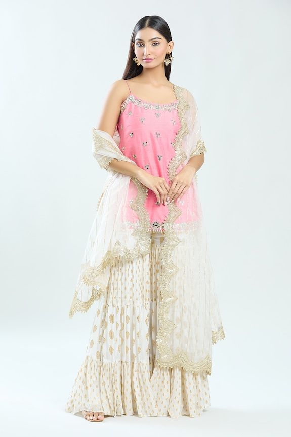 Blush pink straight kurta featuring mirror and pearl hand embroidery with noodle strap shoulder. Paired with an ivory floral buti pattern detailed sharara and a scallop hem dupatta. - Aza Fashions Pink Chinon Sets With Zari Work, Designer Chanderi Sets In Pink, Pink Chanderi Designer Sets, Pink Chanderi Sets For Designer Wear, Pink Chanderi Sharara For Reception, Pink Dori Work Sets For Eid, Pink Traditional Wear With Gota Work For Designer Occasions, Pink Dola Silk Sets With Gota Work, Pink Sharara With Dori Work For Reception