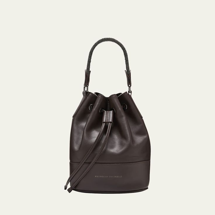 Brunello Cucinelli leather bucket bag with braided monili trim  Top handle Detachable crossbody strap Can be worn as a top handle or crossbody bag  Drawstring closure  Approx. 10.2"H x 9.1"W x 5.5"D Made in Italy Designer Leather Bucket Bag With Detachable Strap, Elegant Evening Bucket Bag With Leather Handles, Leather Bucket Bag With Detachable Strap For Evening, Designer Leather Bucket Bag With Handles, Luxury Leather Bucket Bag With Handles, Leather Bucket Bag With Removable Pouch For Evening, Modern Evening Crossbody Bucket Bag, Designer Bucket Satchel For Evening, Chic Evening Bucket Bag With Leather Handles