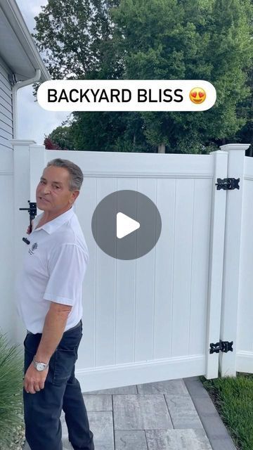 a man standing in front of a white fence with the words backyard bliss on it