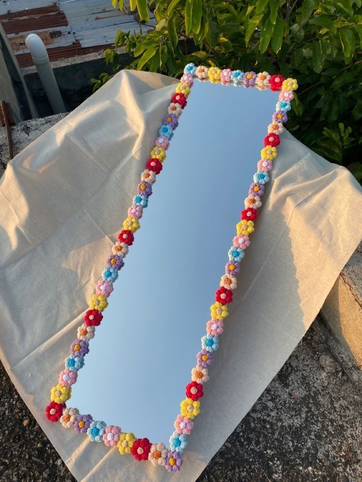 a mirror that is sitting on top of a piece of paper with beads around it