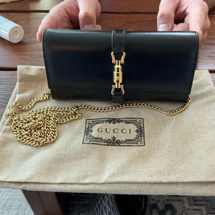 New, Never Worn. Purchased June 2023. Comes With Box And Dust Bag. Style 652681 14j0g 1000 The World Of Jackie 1961 Evolves With The Introduction Of A Continental Wallet With Delicate Chain Strap Allowing It To Be Worn As A Mini Bag. The Gold-Toned Piston Detail Pays Homage To The Original Bag. Here, The Accessory Is Presented In Black Leather. Black Leather Gold-Toned Hardware Viscose Lining Piston Detail 12 Card Slots And Two Bill Compartments, Two Separate Interior Compartments And Zip Coin P Gold Gucci Bag With Original Box, Designer Wallet On Chain With Gold-tone Hardware For Everyday, Designer Wallet On Chain For Everyday Use, Gucci Leather Wallet On Chain, Gucci Leather Wallet On Chain For Everyday Use, Gucci Leather Wallet On Chain For Formal Use, Gucci Leather Wallet On Chain For Formal Occasions, Gucci Evening Wallet On Chain With Chain Strap, Gucci Wallet On Chain For Evening With Chain Strap