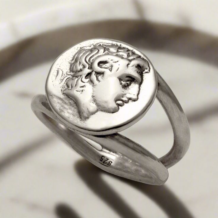 Beautifully handcrafted in sterling silver, this Alexander the Great Portrait Coin Ring is an exquisite piece of Greek jewelry. High quality and detailed, this ring features the powerful ruler's likeness, ensuring timeless style and elegance. Perfect for collectors and history enthusiasts alike. The entire ring is made of sterling silver.  Sterling Silver Ring the brightest of all precious metals Handcrafted Ring. Forget the standardized jewelry on the market! Stand out with our individually ELE Timeless Silver Engraved Round Ring, Luxury Silver Rings With Etched Details, Oxidized Sterling Silver Signet Ring, Sterling Silver Signet Ring With Oxidized Finish, Symbolic Engraved Sterling Silver Ring In White Gold, Symbolic Engraved White Gold Sterling Silver Ring, Symbolic White Gold Sterling Silver Engraved Ring, Symbolic Engraved Ring In White Gold Sterling Silver, Antique Sterling Silver Engraved Open Ring