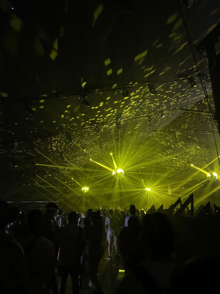 people are standing in the dark with bright lights on their head and arms, all looking at each other