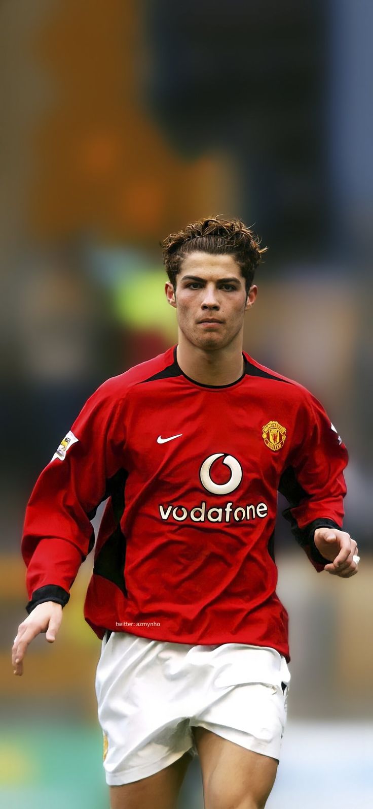 a young man in a red shirt is running with a soccer ball on the field