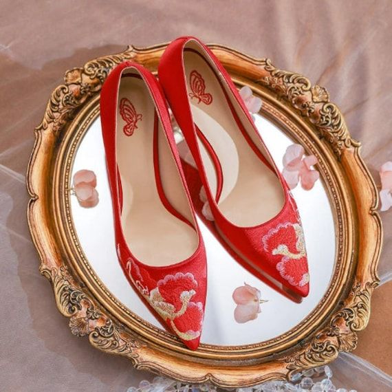 a pair of red shoes sitting on top of a mirror