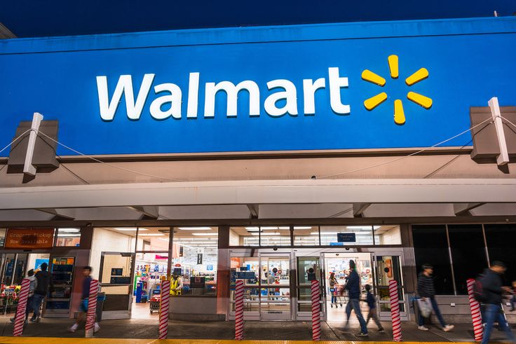 people walking in front of a walmart store with the sign on it's side