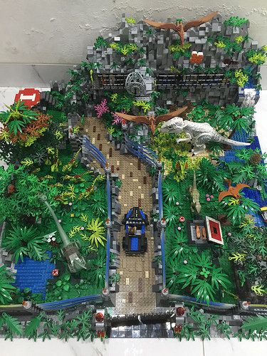 an aerial view of a park with trees and cars on the road in legoland