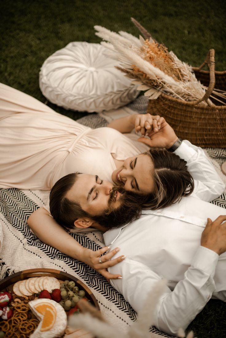 a man and woman laying on the grass together