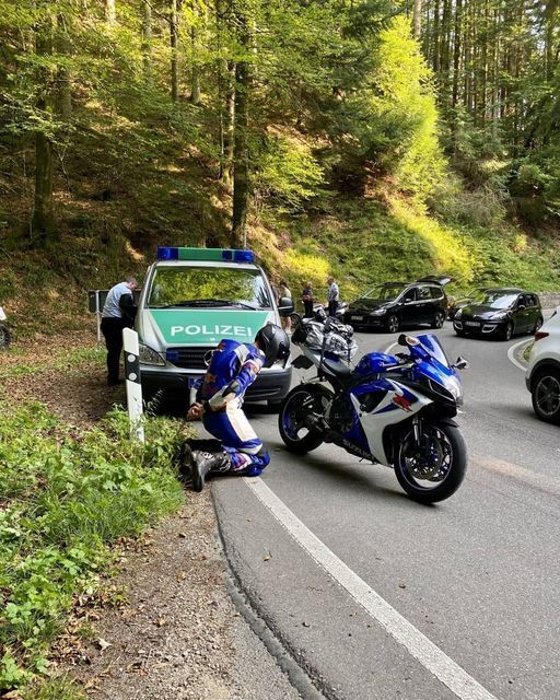 two police motorcycles parked next to each other on the side of a road in front of cars