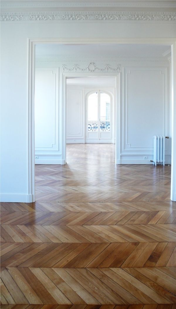 an empty room with white walls and wood floors