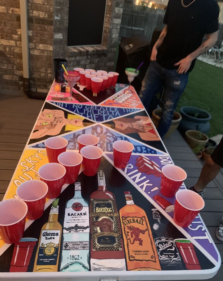 a man standing next to a table filled with drinks