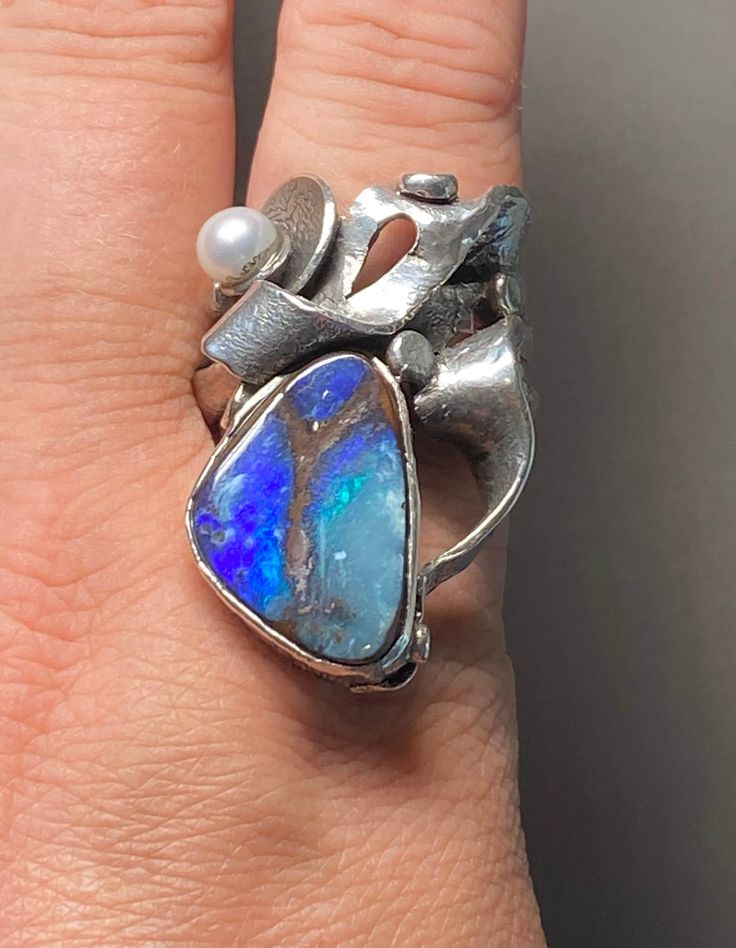 Australian Boulder Opal Gemstone Ring in sterling silver size 9-10 Materials: Silver 925, Australian Opal, Pearl  Face of the ring: Height-35mm, Width-25mm, Band- 20x10mm Unique Handcrafted One-of a-kind Design Ring Each Piece of Jewelry in my Collection is Absolutely One of a Kind! When you start wearing a piece of my jewelry you will fall in love with it more and more each day and feel that good Energy and Love that I pass into it while creating this piece of Art. A piece of Art created for yo Multi-stone Sterling Silver Opal Ring, Unique Oval Opal Ring For Jewelry Making, Unique Collectible Rings With Natural Stones, Sterling Silver Multi-stone Opal Ring As Gift, Artisan Silver Opal Ring For Anniversary, Modernist Gemstone Ring Jewelry, Handmade Unique Sterling Silver Pearl Ring, Unique White Gold Pearl Ring With Gemstone, Unique Multi-stone Opal Rings