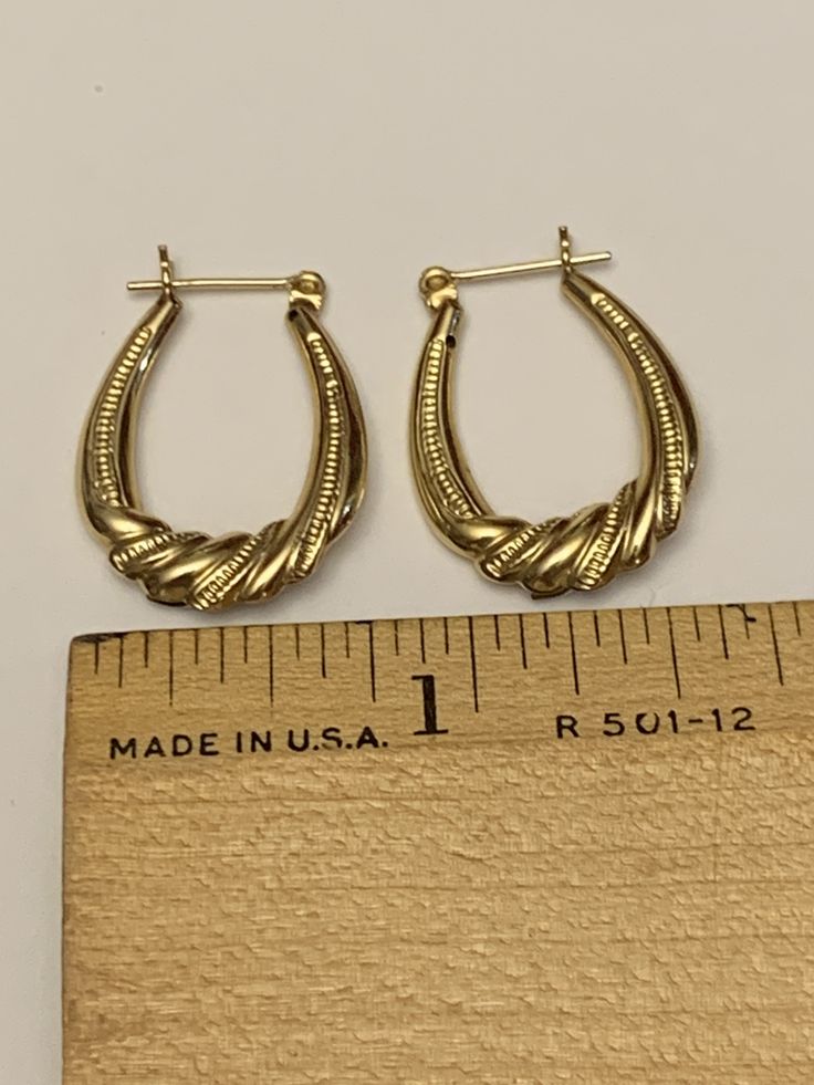 These fantastic hoop earrings are crafted from 10 karat yellow gold with silver accents at the center of each hoop. They have a textured finish and a twisted, rope like motif at the silver accented portion of each earring. These delightful earrings are eye-catching and unique and are sure to spark many a conversation. Their total weight together is 1.7 grams, and each hoop is approximately 0.65 inches across and 1 inch long. Both are in good to very good vintage condition, with minor, age approp Classic 14k Stamped Hoop Earrings, Oval Fine Jewelry Hoop Earrings For Pierced Ears, Yellow Gold Diamond Cut Small Hoop Earrings, 14k Gold Oval Earrings With Diamond Cut, Oval 14k Gold Diamond Cut Earrings, Oval Diamond Cut 14k Gold Earrings, Small Hoop Huggie Earrings For Formal Occasions, Classic Pierced Hoop Earrings For Anniversary, Gold Sterling Silver Hoop Earrings With Diamond Cut