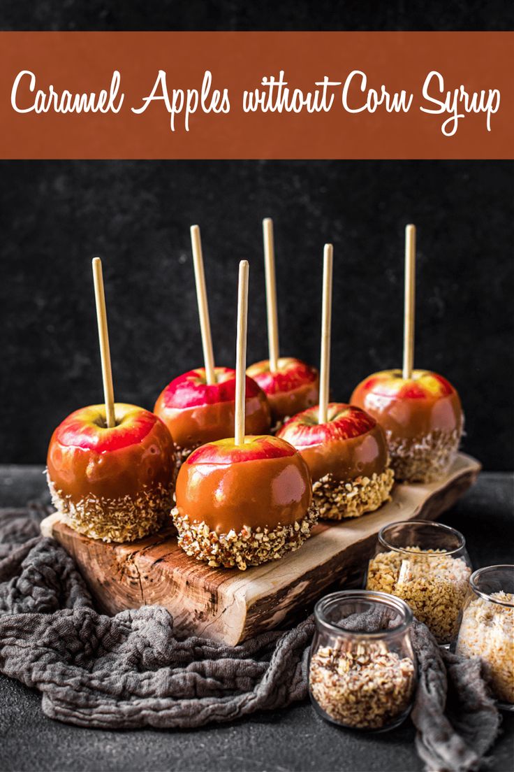 caramel apples without corn syrup are arranged on a wooden platter with toothpicks