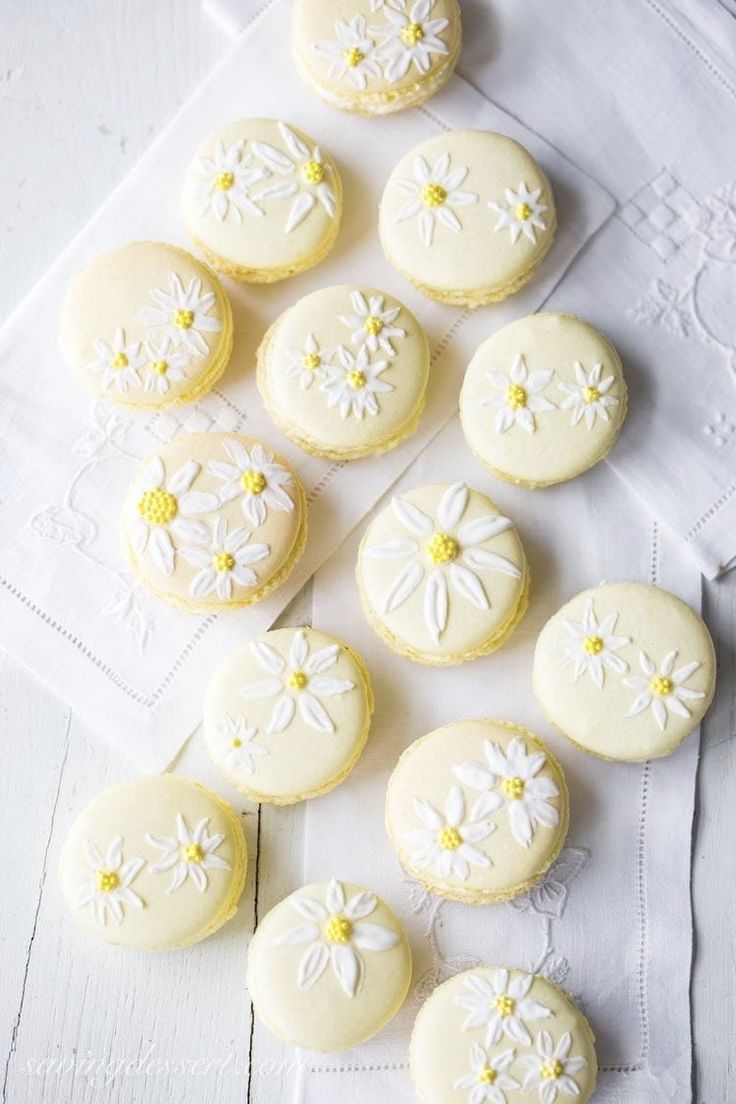 several decorated cookies sitting on top of a white table cloth next to eachother