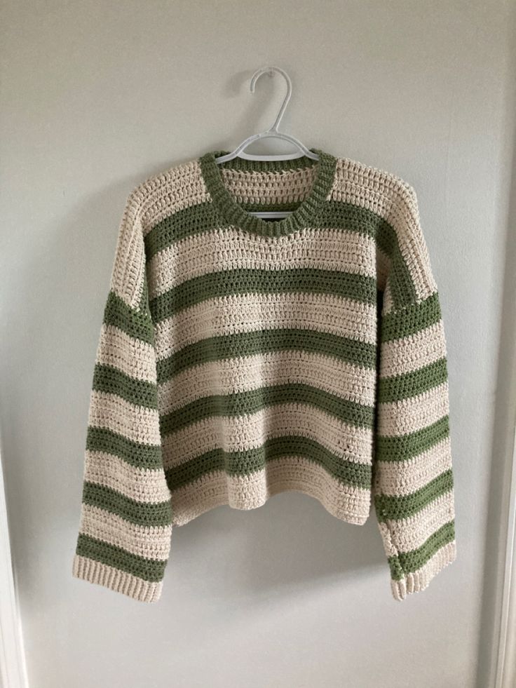 a green and white striped sweater hanging on a wall