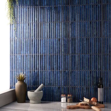 a blue tiled wall in a kitchen with wooden utensils on the counter top