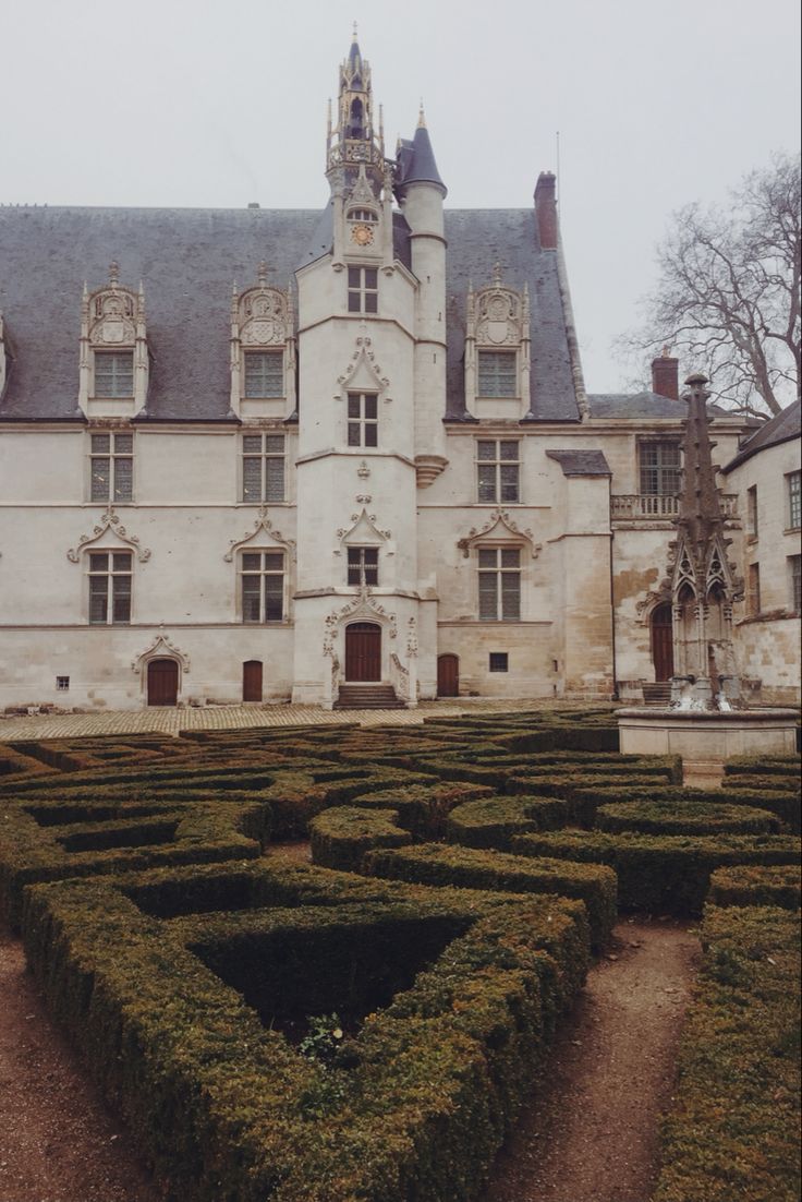 an old building with a large garden in front of it