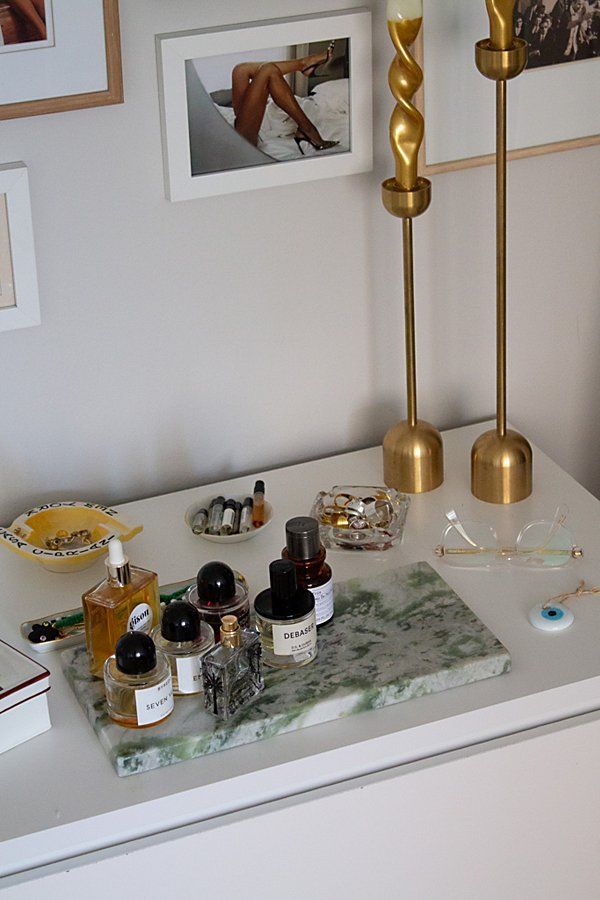 an assortment of beauty products sit on a counter in a room with pictures and other items