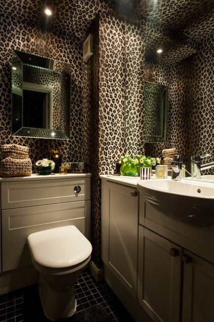 a bathroom with leopard print wallpaper and white fixtures, including a toilet and sink