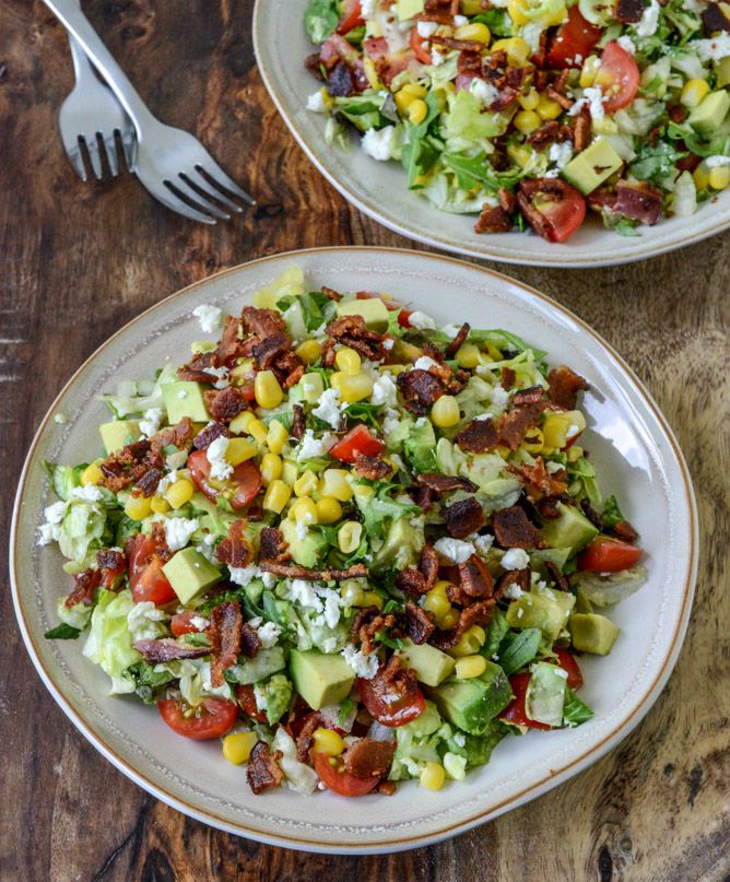 two plates filled with salad on top of a wooden table