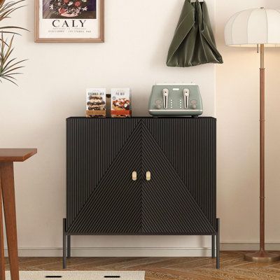 a black cabinet sitting on top of a wooden floor next to a lamp and table