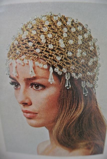 a woman wearing a gold headpiece with pearls and tassels on her head